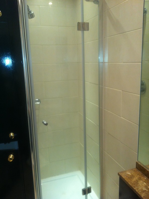 Frameless glass shower enclosure with chrome fittings in Purley